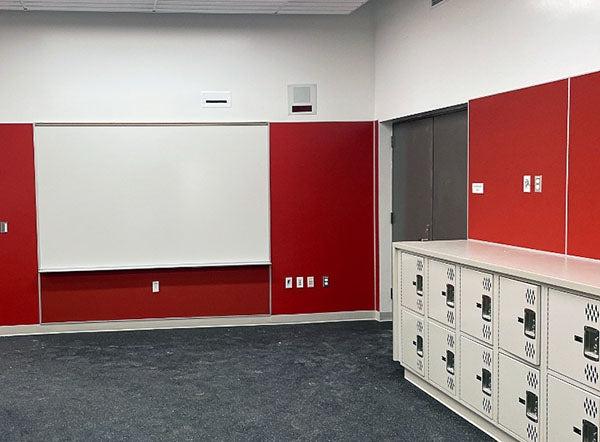 white board and low lockers in a room with red walls