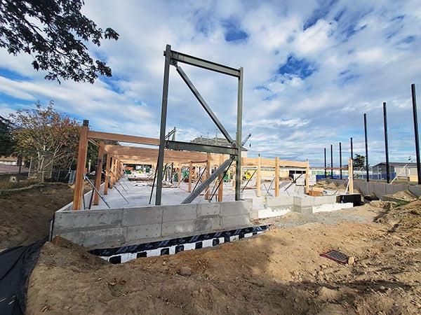a concrete foundation has glulam beams and structural steel installed