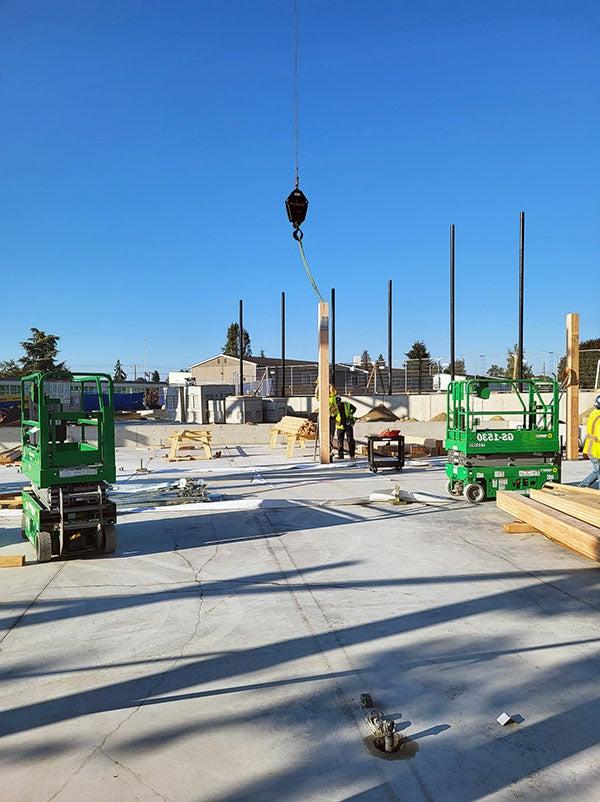 a glulam column is being lifted into place by a crane