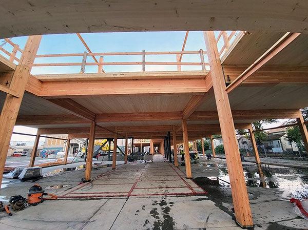 a building under construction with wood columns and decking