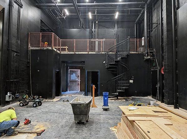 construction area in a black room with a sprial staircase