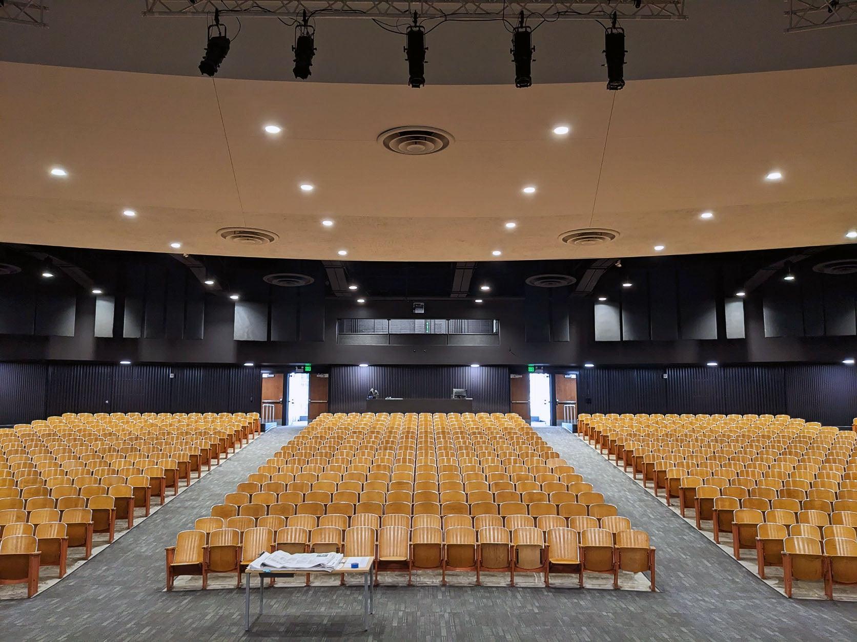a large room with theatre style seating in three sections and a carpeted floor