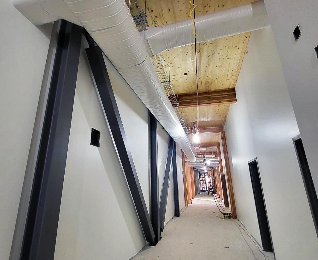 a long hallway with steel bracing and a wood ceiling