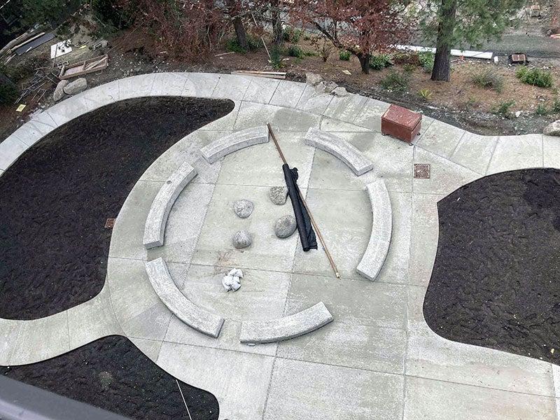 four pathways lead to a central circle with curved seating and boulders in the center