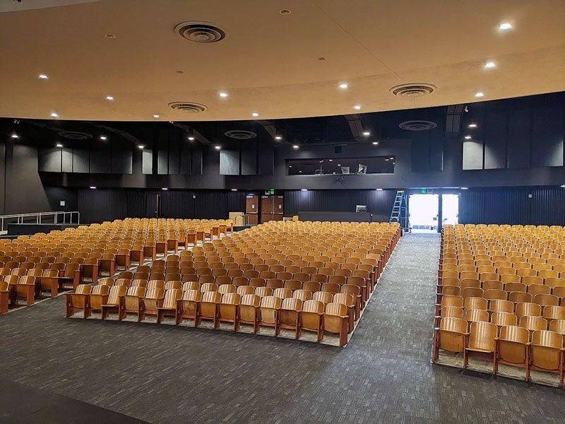 an auditorium view from the front with tiered rows of theater seats 
