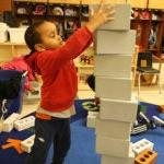 A young student stacks blocks in a classroom