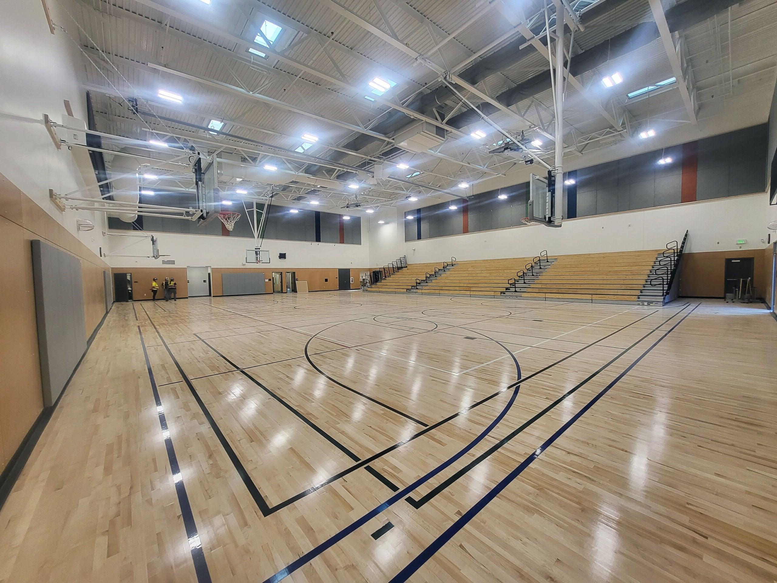 a gymnasium with bleachers on one wall